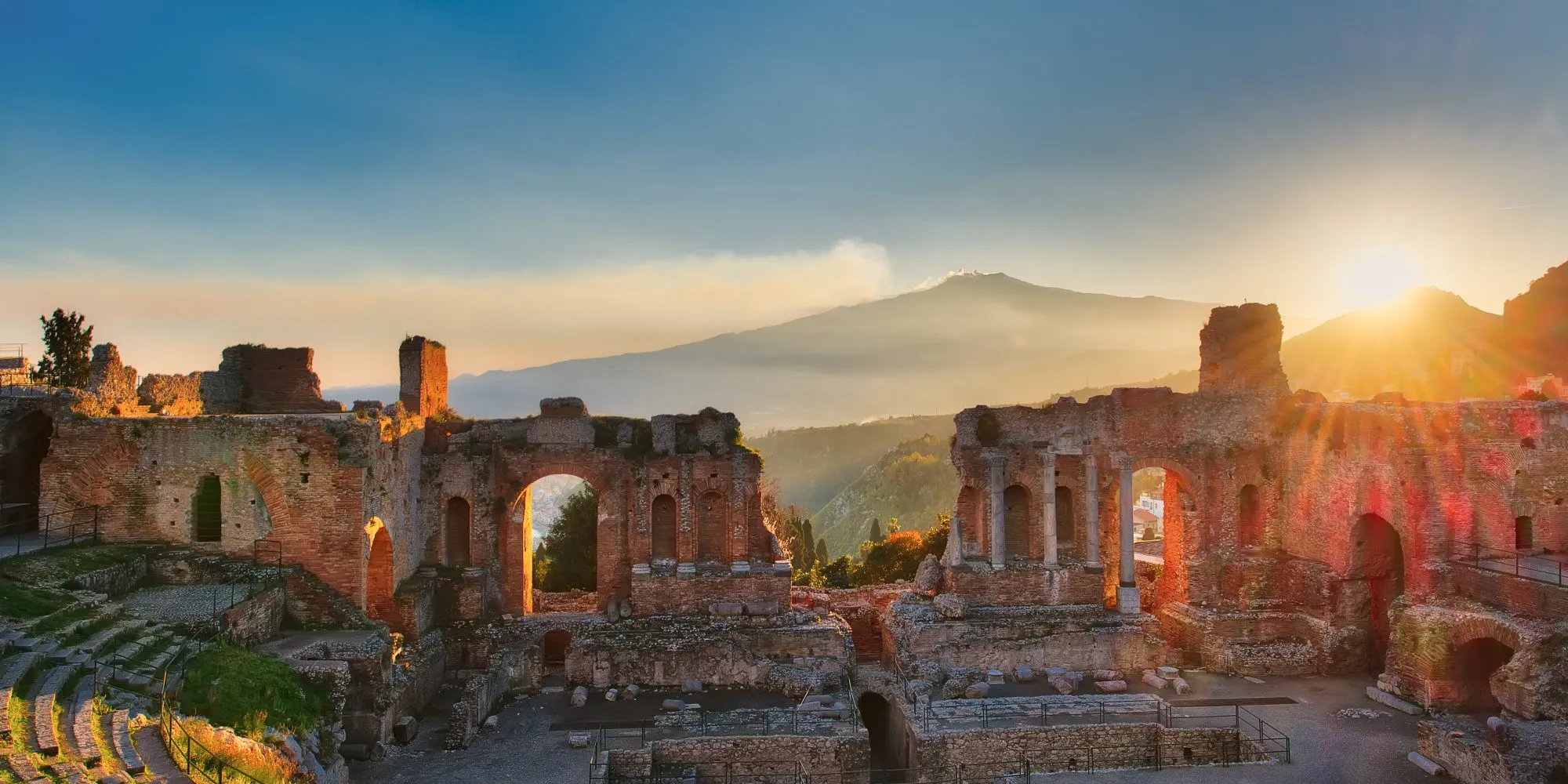 Particular of Ancient theatre of Taormina  Sicily Italy with Etna  erupting volcano at sunset